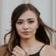Portrait de Kira Whittle, posant devant un fond clair, les cheveux au vent et un regard serein